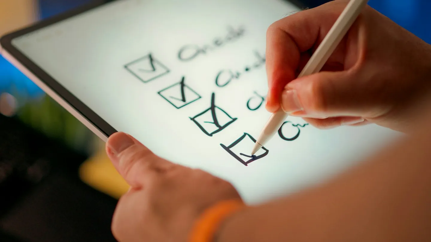 Hand checking off items on a document checklist